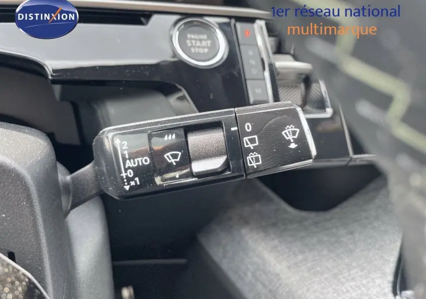 Gros plan sur la commande des essuie-glaces et le bouton start du Peugeot 5008 hybride noir métal, intérieur moderne.