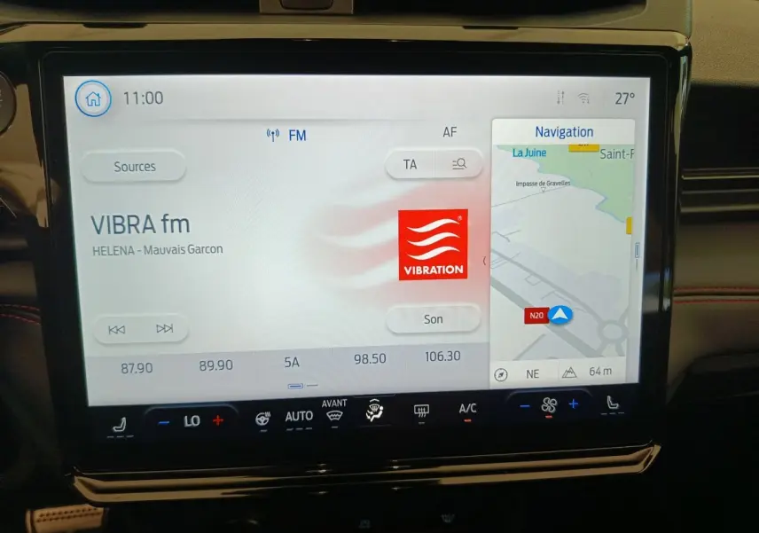 Écran tactile central du tableau de bord du Ford Puma bleu 2025, affichant radio et navigation GPS.