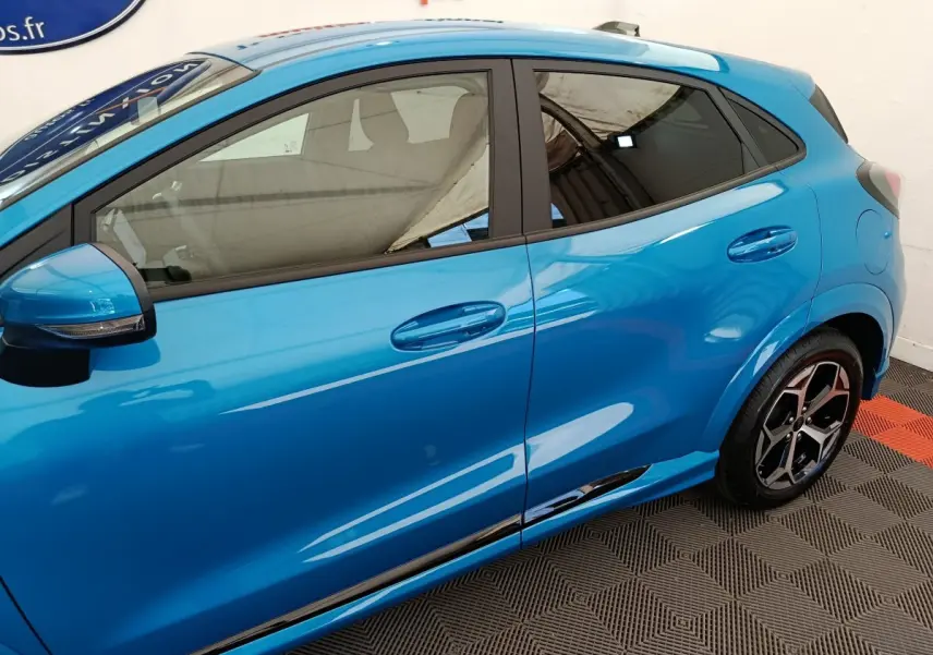 Vue latérale gauche du Ford Puma bleu 2025 avec jantes alliage et rétroviseur noir intégré clignotant.