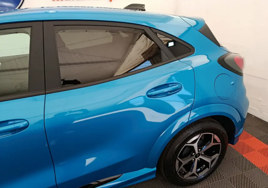 Vue côté droit arrière du Ford Puma bleu 2025 avec jantes alliage et vitres teintées.
