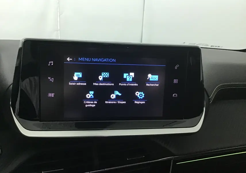 Écran tactile central du tableau de bord de la Peugeot 208 GT 2023 affichant le menu navigation en intérieur noir et gris.