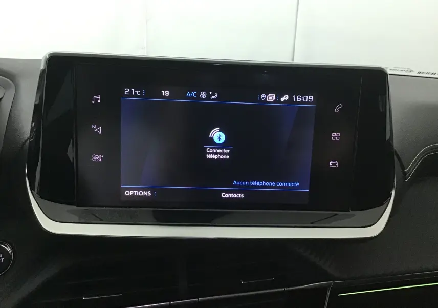 Écran tactile central de la Peugeot 208 1.2 PureTech 100 GT 2023 affichant la connexion Bluetooth et la température intérieure.