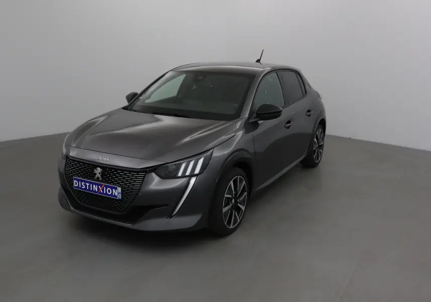 Peugeot 208 gris platinium vue 3/4 avant droit, avec calandre noire et feux LED distinctifs.