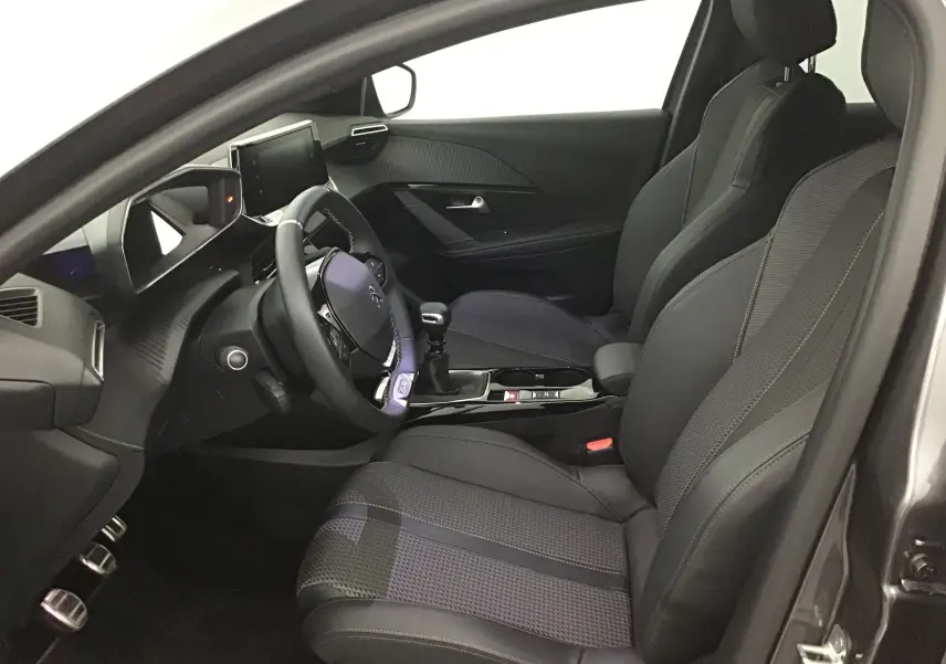 Intérieur avant gauche du Peugeot 208 1.2 PureTech 100 GT S&S 2023 avec sièges cuir et volant multifonction.