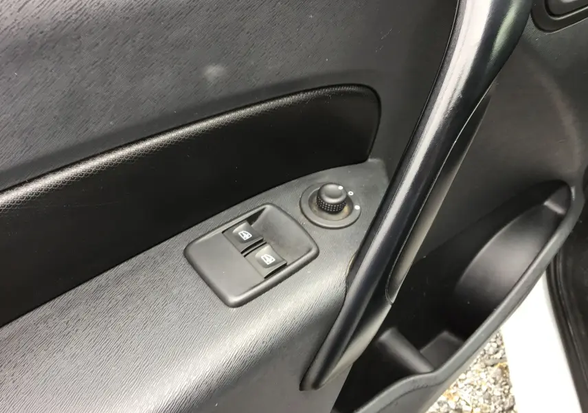 Détail de la porte avant gauche du Renault Kangoo blanc 2019, avec commandes électriques des vitres et réglage des rétroviseurs.