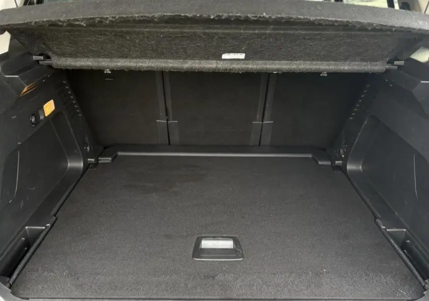 Coffre ouvert vu de l'arrière d'un Citroën C5 Aircross gris Platinium, montrant un espace de chargement spacieux et noir.