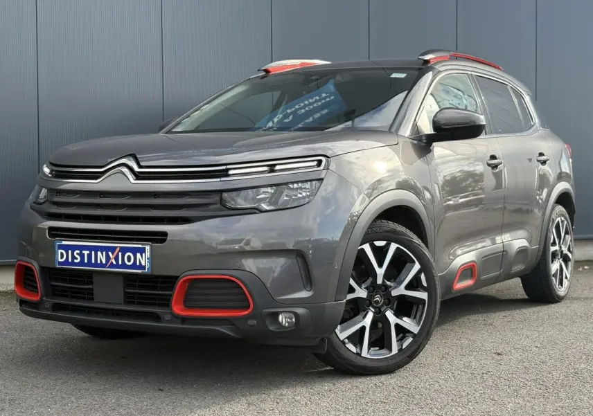 Vue 3/4 avant droit du Citroën C5 Aircross gris Platinium avec inserts rouges et jantes alliage 19 pouces diamantées.