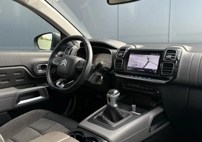 Intérieur du Citroën C5 Aircross 2020 côté conducteur, volant cuir, écran GPS tactile et levier de vitesses manuel.