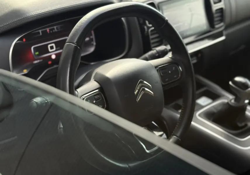 Vue rapprochée du volant cuir et tableau de bord numérique du Citroën C5 Aircross 1.5 BlueHDi 130 gris Platinium.