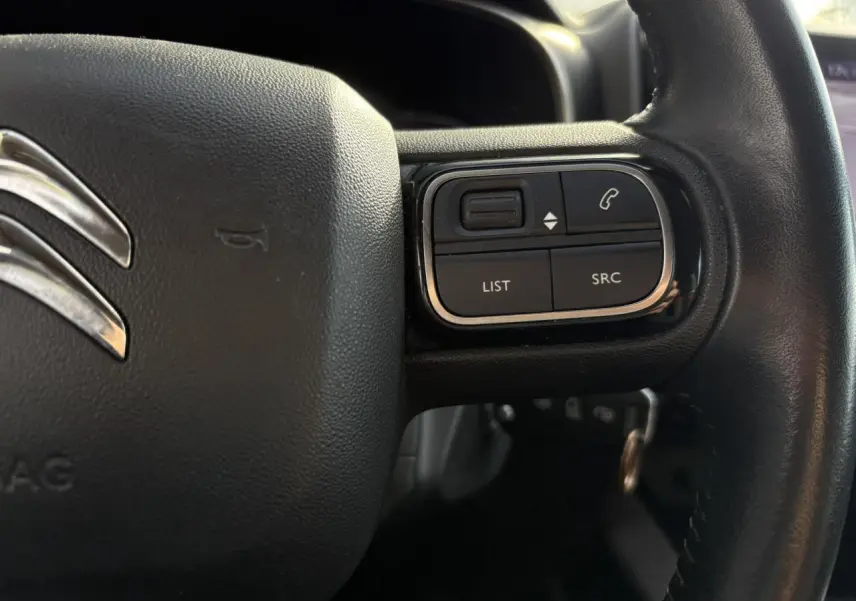 Gros plan sur les commandes du volant en cuir noir du Citroën C5 Aircross 2020, version Feel.