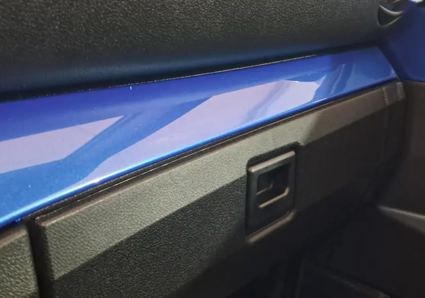 Détail intérieur montrant la planche de bord avec bandeau bleu brillant sur AIXAM AMBITION 2026 côté passager.