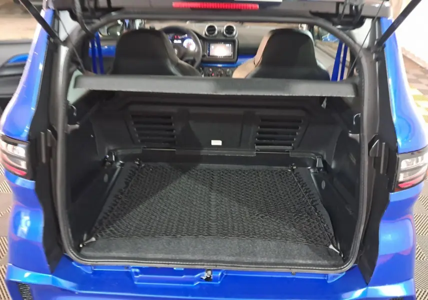 Coffre ouvert vu de l'arrière d'une AIXAM AMBITION bleu 2026 avec intérieur noir et filet de rangement.