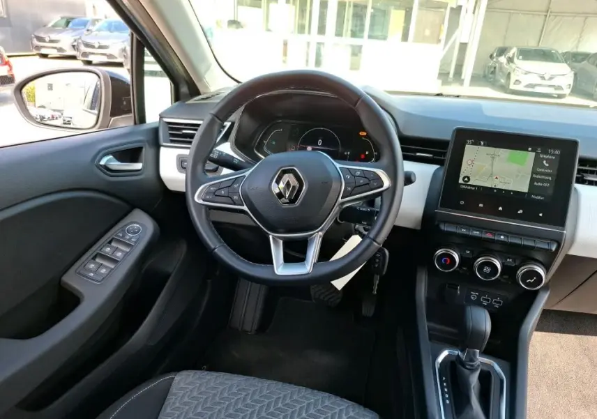 Vue intérieure de face du volant et tableau de bord de la Renault Clio 1.6 E-Tech gris platine avec écran tactile et boîte automatique.