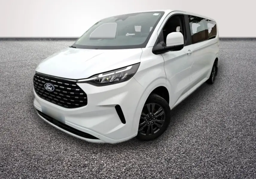 Ford Tourneo Custom blanc en 3/4 avant droit, avec calandre noire et jantes foncées visibles sur sol gris.
