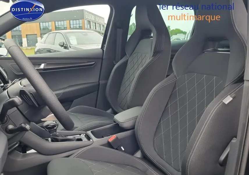 Intérieur avant du Skoda Karoq noir 2025, sièges sport avec surpiqûres contrastées et accoudoir central visible.