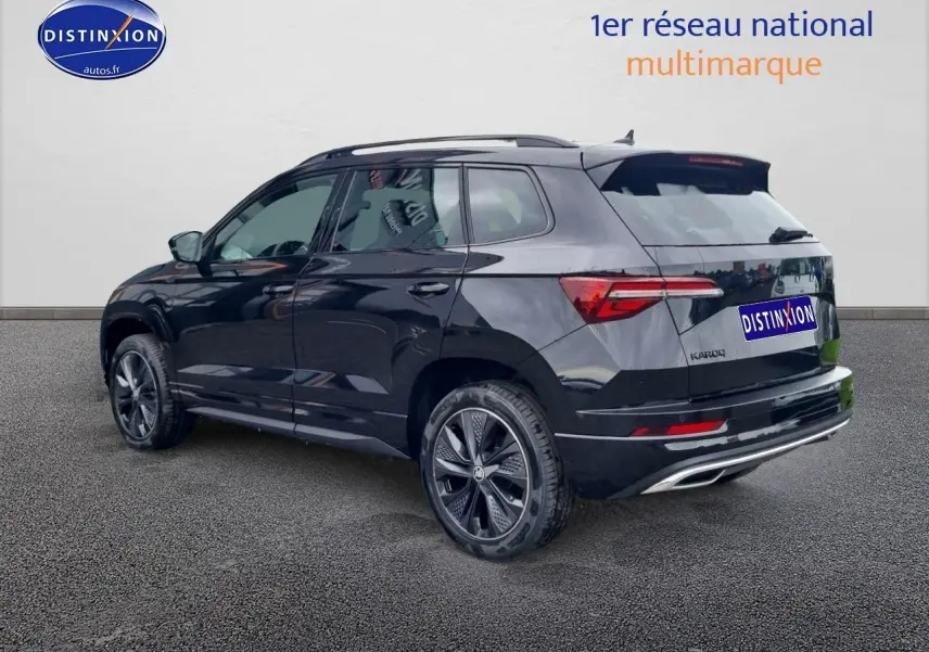 SUV SKODA KAROQ noir vu en 3/4 arrière droit avec jantes alu et barres de toit visibles