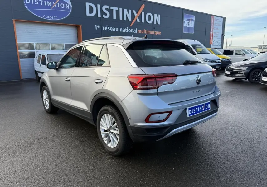 Volkswagen T-Roc gris pyrite vue 3/4 arrière droit sur parking devant concession multimarque