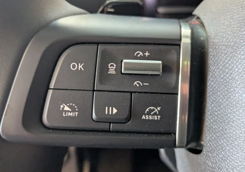 Gros plan sur les commandes noires du volant du Citroën C4 gris platinium, avec boutons de limitation et assistance.