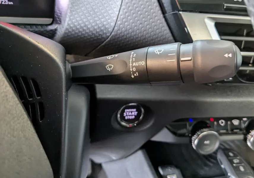 Gros plan sur la commande d'essuie-glace côté gauche du tableau de bord gris noir de la Citroën C4 2024.