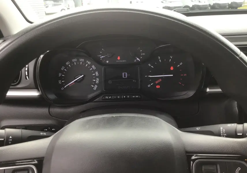 Vue intérieure du tableau de bord de la Citroën C3 blanche 2021, avec compteur analogique et écran digital au centre.