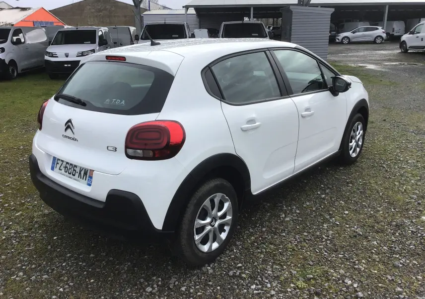 Vue 3/4 arrière droite d'une Citroën C3 blanche 2021 avec feux arrière distinctifs et jantes alliage.