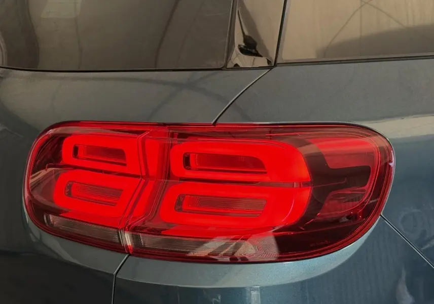 Gros plan sur le feu arrière droit rouge d’un Citroën C5 Aircross Hybrid 225 bleu métallisé.