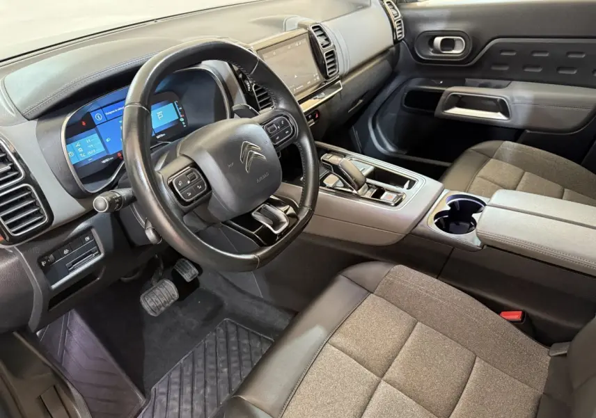 Vue intérieure côté conducteur du Citroën C5 Aircross Hybrid avec tableau de bord numérique et sellerie grise.