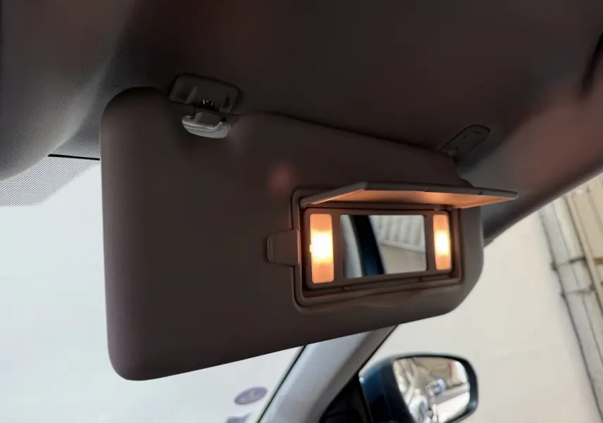 Miroir de courtoisie éclairé sur pare-soleil côté conducteur dans l’habitacle d’un Citroën C5 Aircross bleu.