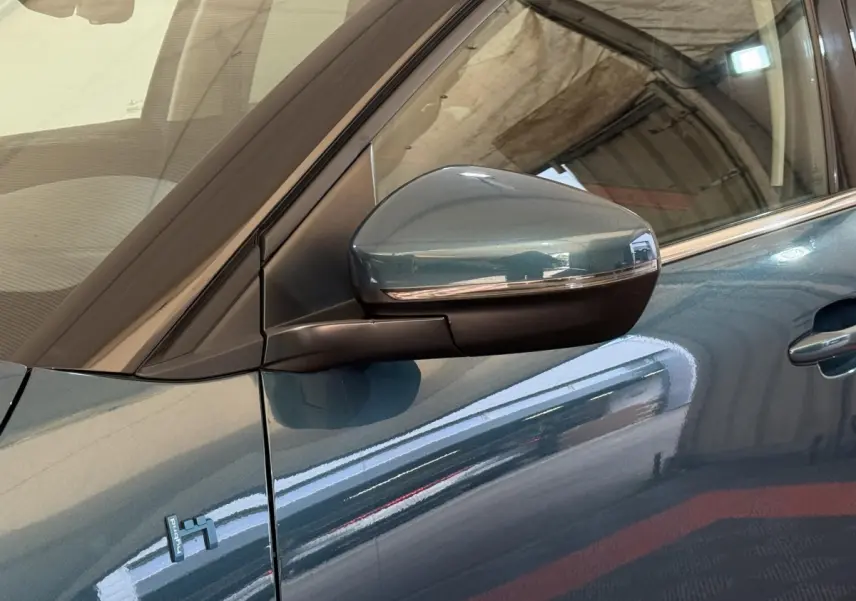 Gros plan sur le rétroviseur droit bleu métallisé du Citroën C5 Aircross Hybrid 225 ë-EAT8 avec badge Hybrid visible sur la portière.