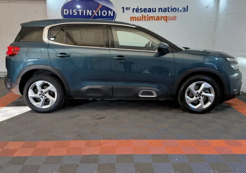 Vue profil droit d'un Citroën C5 Aircross Hybrid 225 bleu, avec jantes alliage et protections noires sur bas de caisse.