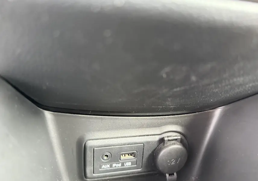 Gros plan sur la prise USB, entrée AUX et prise 12V du tableau de bord d'une KIA VENGA gris 1.4 i 90 ACTIVE 2013.