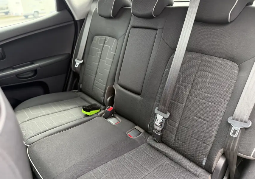 Vue intérieure côté droit des sièges arrière en tissu gris foncé de la Kia Venga 1.4 i 90 Active avec ceinture de sécurité visible.