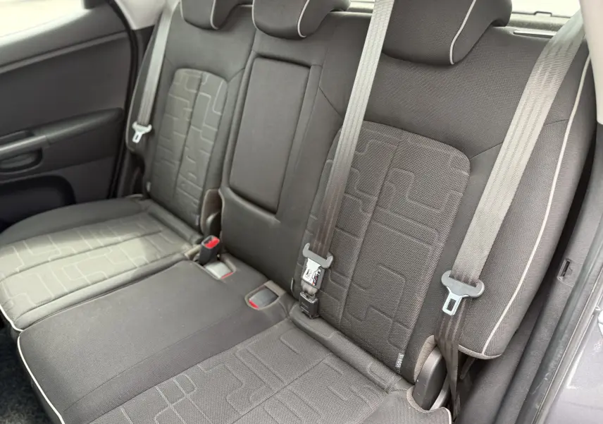Vue intérieure sur les sièges arrière en tissu gris avec ceintures de sécurité de la Kia Venga 1.4 i 90 Active de 2013.
