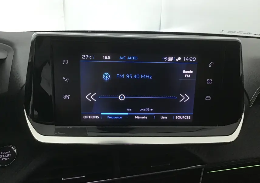 Écran tactile central affichant la radio FM dans l'habitacle d'une Peugeot 208 1.2 PureTech 100 GT S&S 2023.