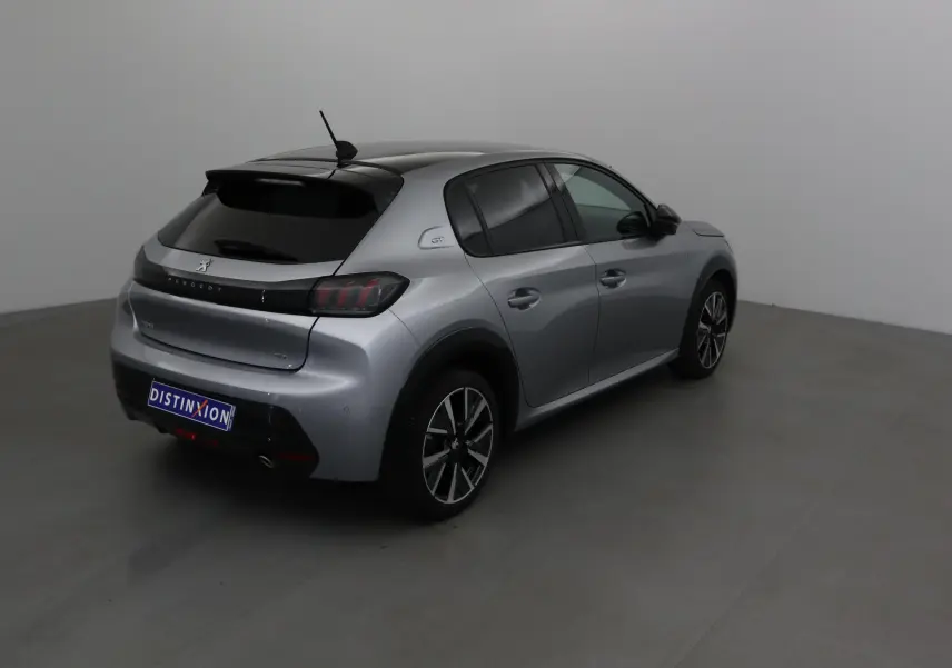 Peugeot 208 gris Artense avec toit noir, vue 3/4 arrière côté droit, jantes alliage et feux arrière LED.