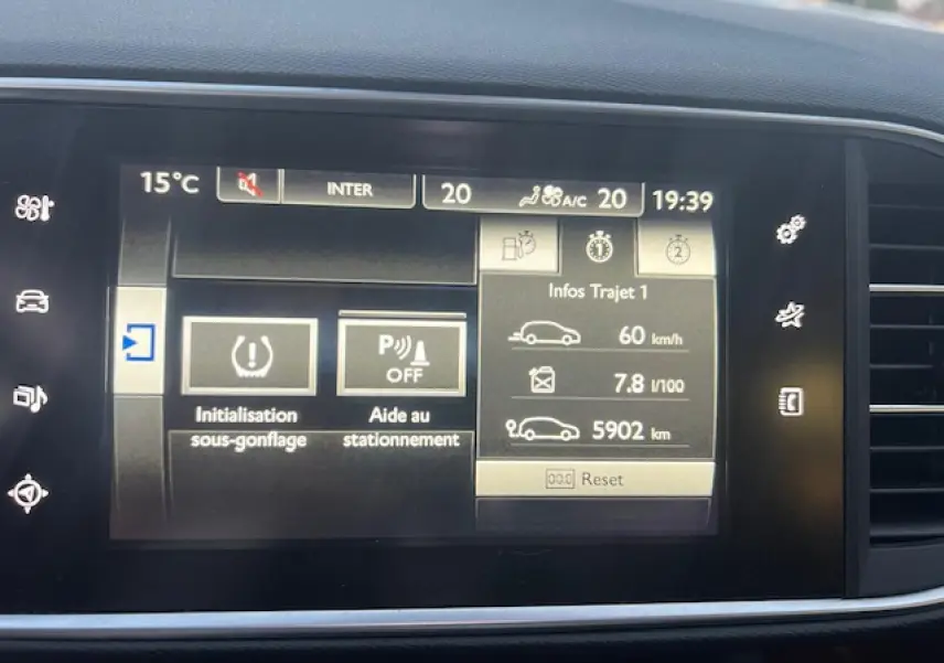 Écran tactile multifonction de Peugeot 308 blanc, affichant l'aide au stationnement et l'initialisation sous-gonflage.