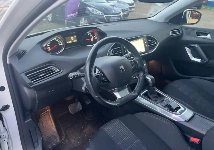 Intérieur de la Peugeot 308 blanc vue côté conducteur, tableau de bord avec écran tactile et volant multifonctions.