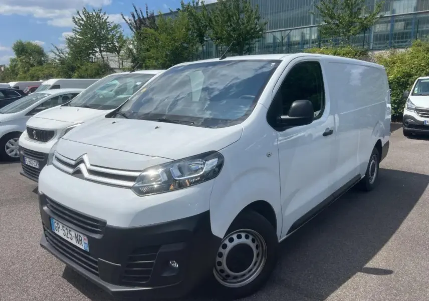 Fourgon Citroën Jumpy blanc en vue 3/4 avant droit, avec pare-chocs noirs et jantes tôles grises.