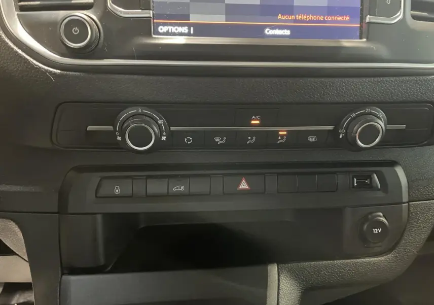 Détail de la console centrale noire du Citroën Jumpy blanc 2023 avec commandes climatisation et prise 12V visible