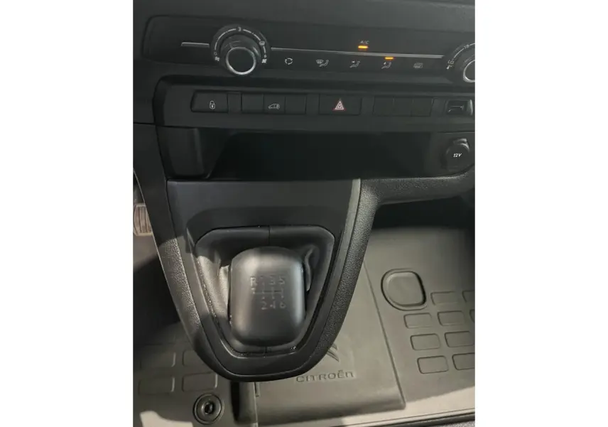 Gros plan sur la boîte manuelle noire et la console centrale du Citroën Jumpy XL blanc, avec tapis de sol marqué Citroën.
