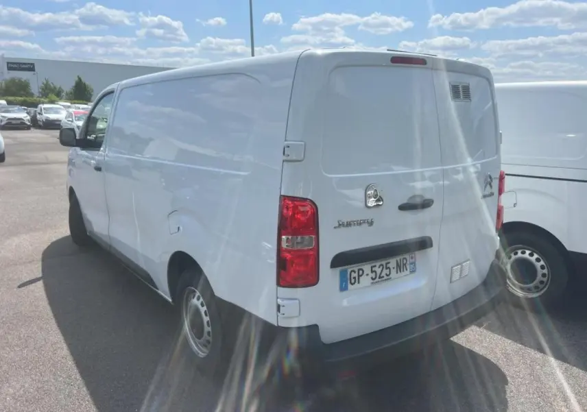 Vue 3/4 arrière droite d'un utilitaire Citroën Jumpy blanc avec portes battantes et jantes tôles grises.