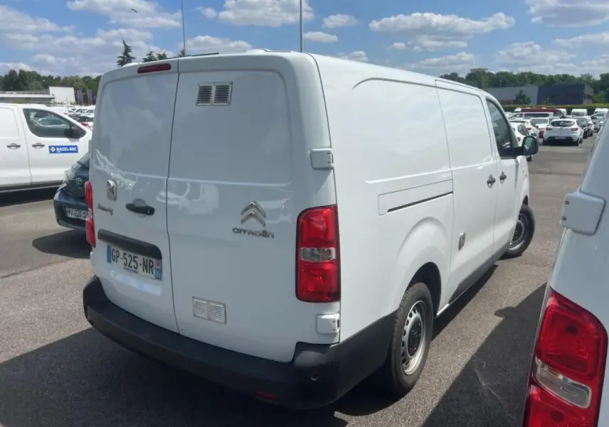 Vue 3/4 arrière droite d'un utilitaire Citroën Jumpy XL blanc avec portes battantes et jantes tôles noires.