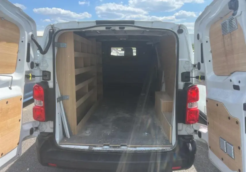 Vue arrière du Citroën Jumpy XL blanc 2023 avec portes battantes ouvertes et aménagements bois dans l'espace de chargement.