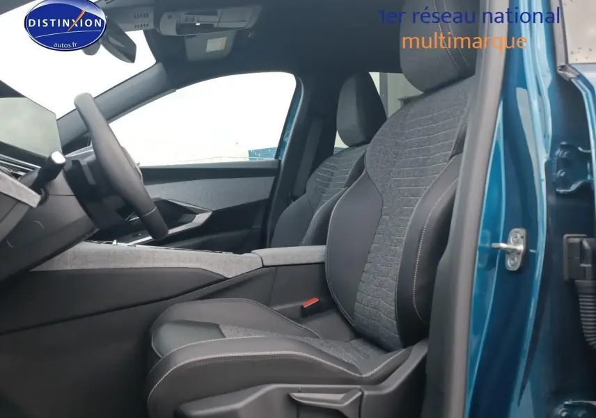 Vue intérieure côté conducteur du Peugeot 3008 bleu 2025, mettant en valeur les sièges bi-matière gris et noir avec surpiqûres.