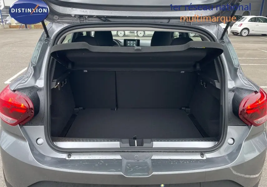 Coffre ouvert vu de l'arrière d'une Dacia Sandero Stepway 2024 gris schiste métal, montrant l'espace de chargement vide.