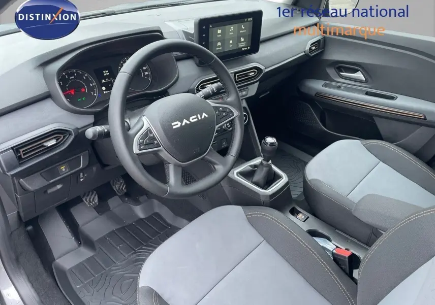 Intérieur avant de la Dacia Sandero Stepway 2024, volant multifonction, sièges gris clair et tableau de bord moderne.