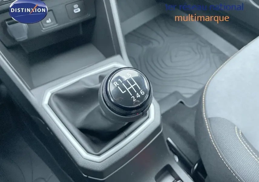 Le levier de vitesses manuel noir de la Dacia Sandero Stepway 2024, entouré de garnitures grises et siège tissu gris.