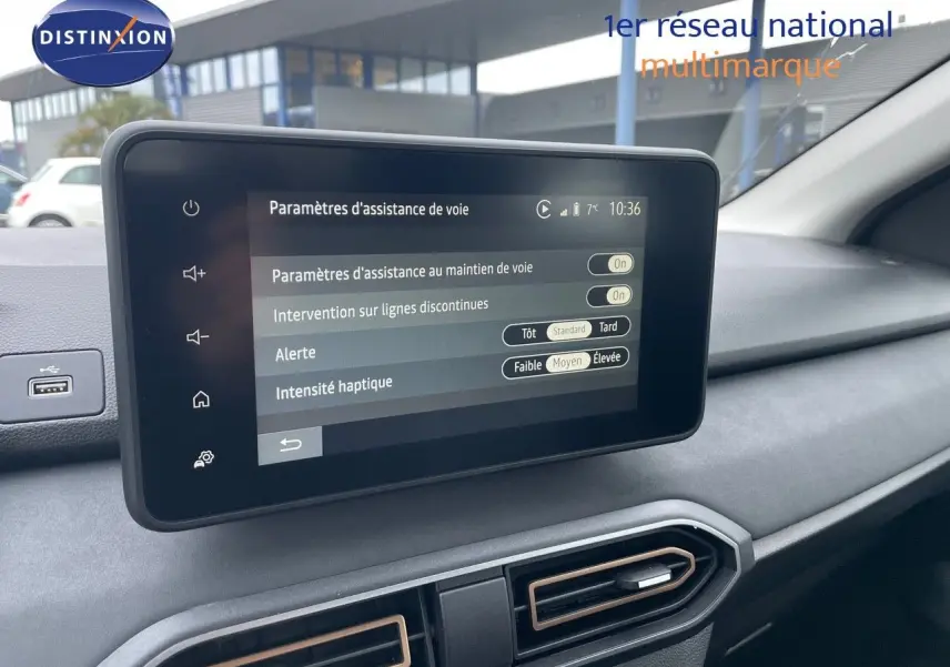 Écran tactile central affichant les paramètres d'assistance de voie dans l'habitacle gris du Dacia Sandero Stepway 2024.