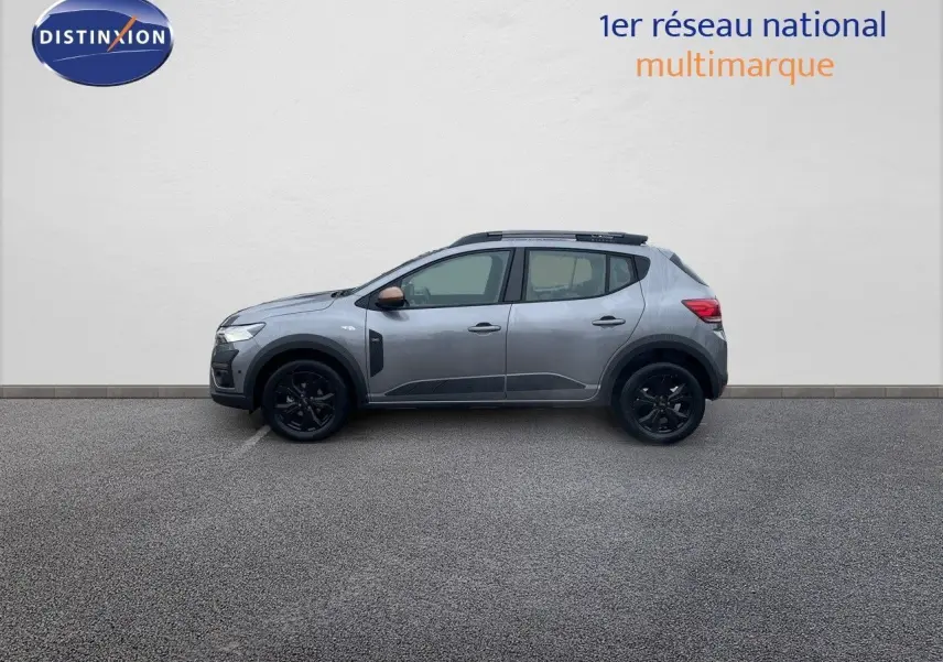 Profil droit d'une Dacia Sandero Stepway 2024 gris schiste métal avec jantes noires et rétroviseurs bronze.