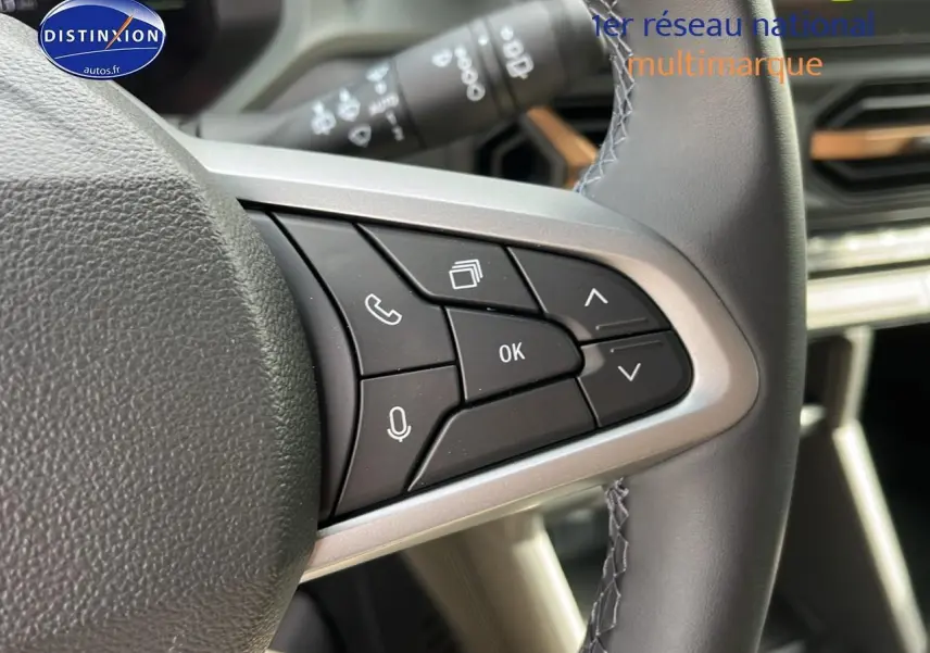 Gros plan sur les commandes multifonctions à droite du volant du Dacia Duster 2025 finition Journey couleur Sandstone.